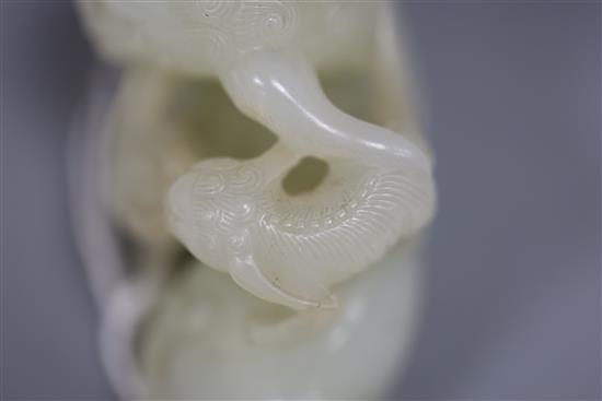 A Chinese pale celadon jade figure of a lion dog and cub, 18th/19th century, L. 6cm, wood stand